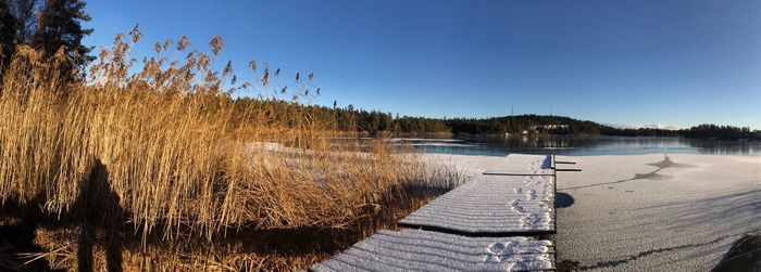 Scenic view of lake against clear sky during winter