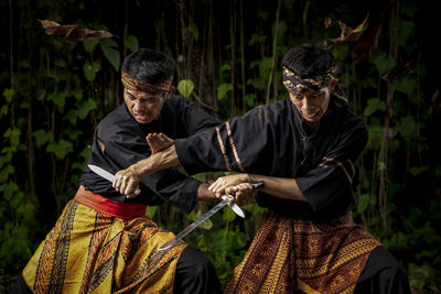 Men practicing martial arts with knives