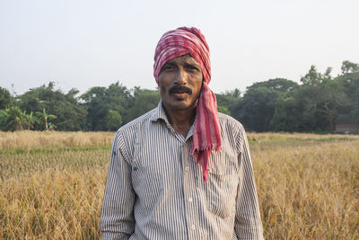 Portrait of young man standing on field