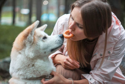 Woman feeding dog outdoors