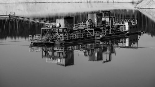 Metallic structure in lake against sky