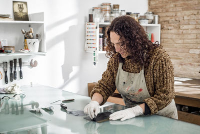 Woman artist preparing ink for an art print. using an ink stick