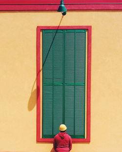 Rear view of man standing against wall