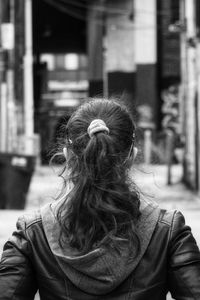 Rear view of woman with umbrella on street in city