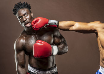 Boxers fighting against brown background