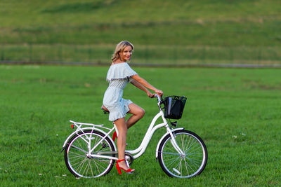 Woman riding bicycle on field