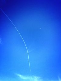 Low angle view of vapor trail in blue sky