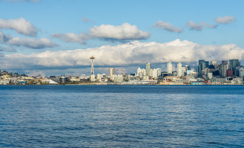 Architecture of the seattle skyline with elliott bay in front and clouds above.