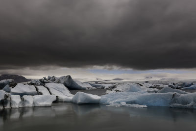 Iceberg in sea against sky during winter