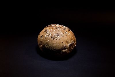 Close-up of bread on table against black background