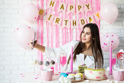  attractive woman in white party clothes celebrating birthday taking selfie on mobile