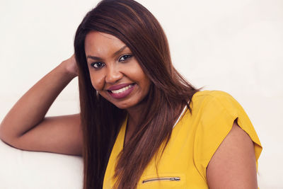 Portrait of smiling young woman against white background