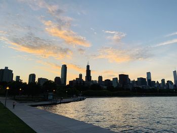 Modern buildings in city against sky during sunset