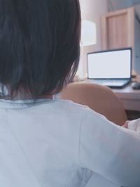 Rear view of woman working on table