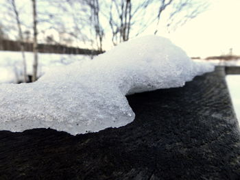 Close-up of frost on snow against sky