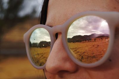 Cropped image of woman wearing sunglasses with reflection