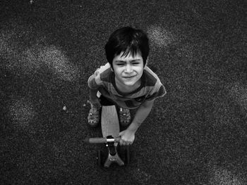 High angle view of boy with push scooter on road