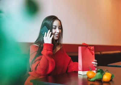 Young woman using phone on table