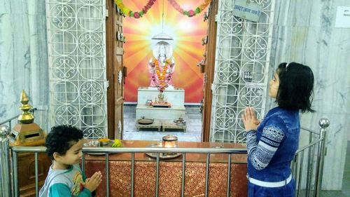 Rear view of women standing at temple