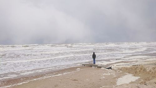 Man standing on beach against sky