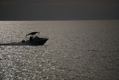 Silhouette man in boat on sea