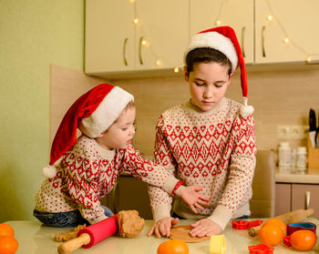 Funny kids making cookie for santa in warm kitchen. santa chefs