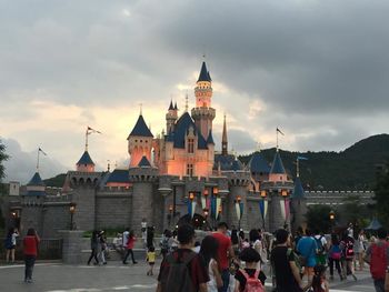 People in city against cloudy sky