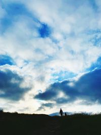 Silhouette man standing on field against sky