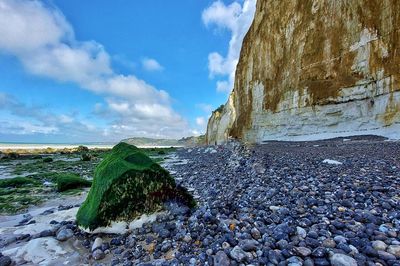 Surface level of stones on beach against sky