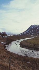 Scenic view of lake against cloudy sky during winter