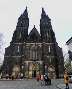 People in front of historic building against sky