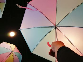 Low section of man holding umbrella against clear sky