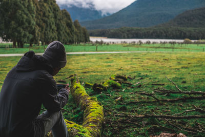 Rear view of man sitting on land