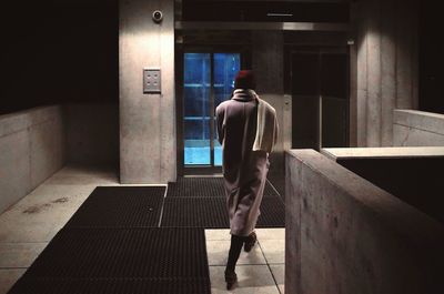 Rear view of woman walking in corridor