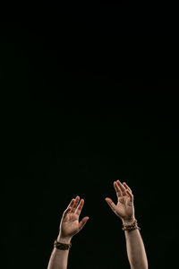 Low angle view of hand against black background