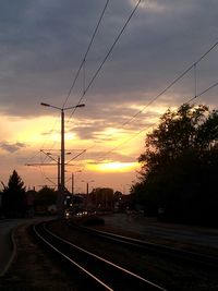 Electricity pylon against cloudy sky