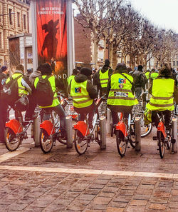 Rear view of people riding bicycles on street