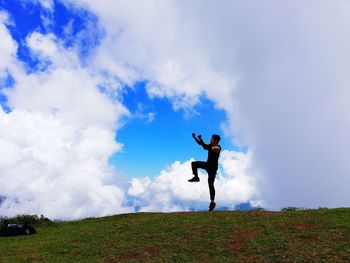 Man and woman standing on field against sky