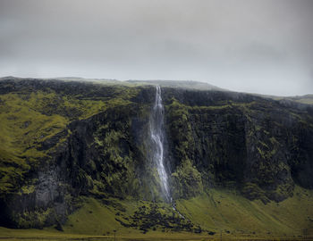 Scenic view of waterfall against sky