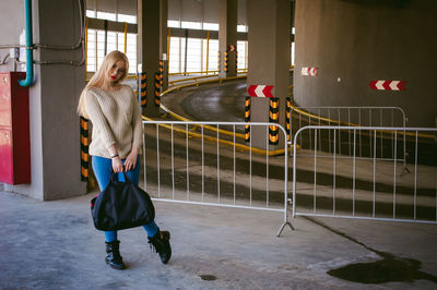 Portrait of young woman standing in parking lot