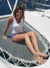 Portrait of smiling young woman sitting on boat sailing in sea