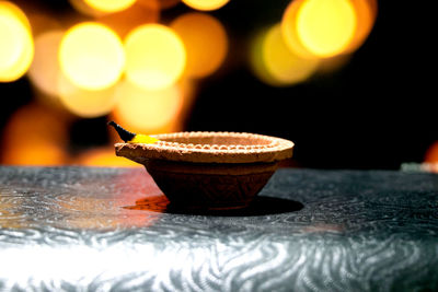 Close-up of illuminated tea light candle on table