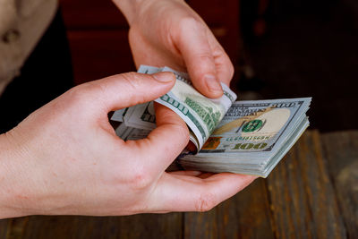 Cropped image of hands counting paper currencies