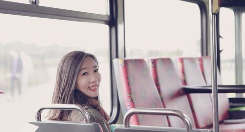 Portrait of happy commuter sitting in bus
