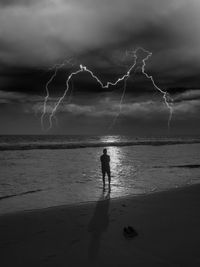 Silhouette of people on beach against sky