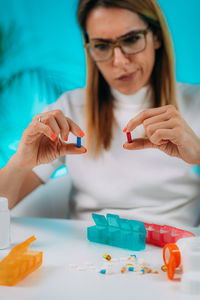 Midsection of woman holding eyeglasses on table