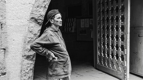 Portrait of man standing against wall of building