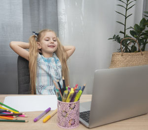 Woman using mobile phone while sitting on table