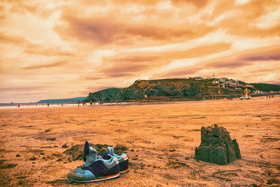 Scenic view of beach against cloudy sky