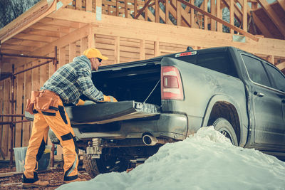 Side view of man opening car trunk